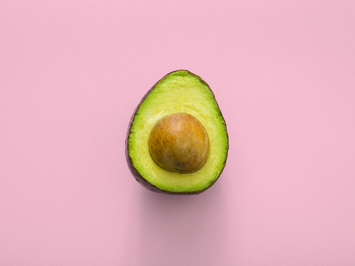 Half an avocado on a pink background