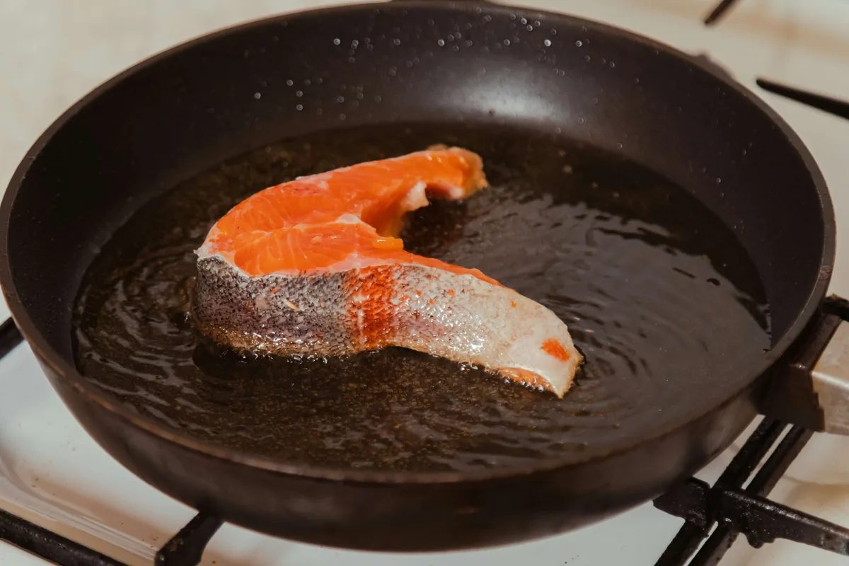 Salmon fillet cooking in a frying pan