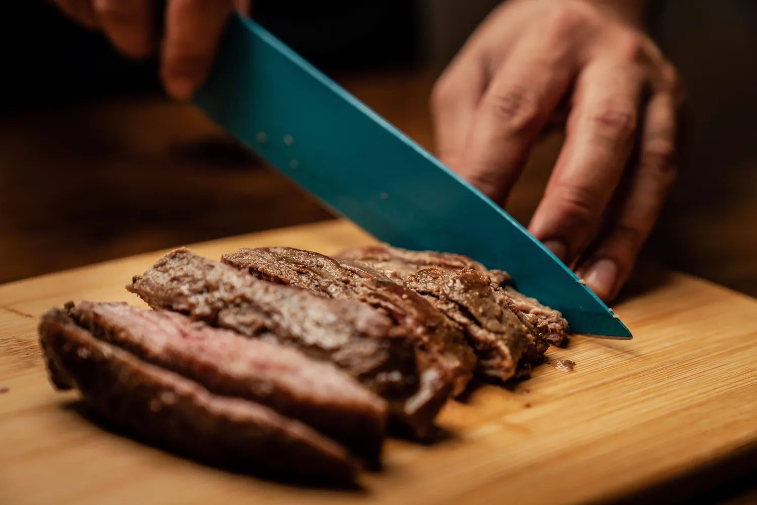Pečen zrezek, ki ga režejo na leseni deski, beljakovinsko bogata osnova carnivore diete