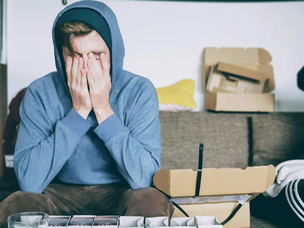 A tired man sitting with his hands over his face